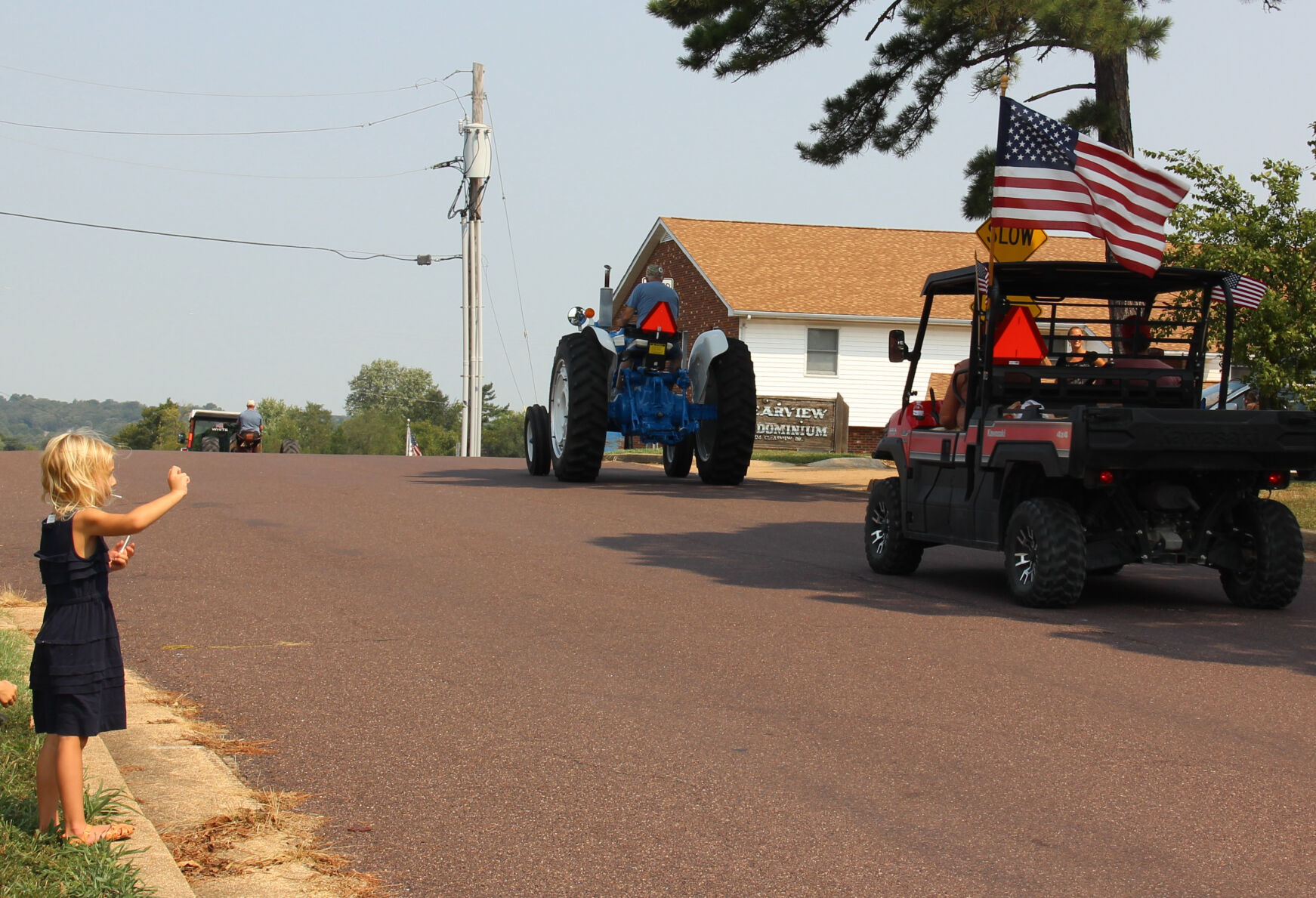 Lena Percival waves to passing vehicles
